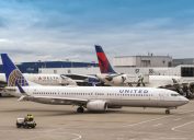 Two Delta planes at the gate while a United plane taxis behind them