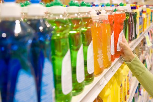 Woman selecting dishwashing liquid product in supermarket