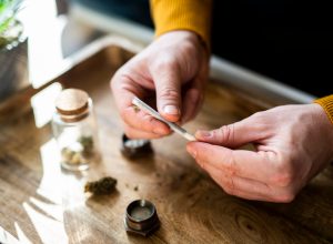 Close-up of a unrecognizable man's hands preparing a joint of marijuana.