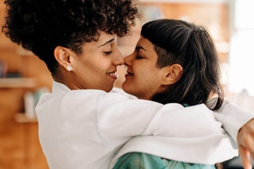 Two women smiling and embracing each other.