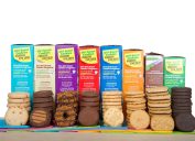 Girl Scout cookies in a row stacked in front of their colorful boxes