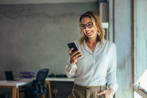 business woman smiling while on her phone