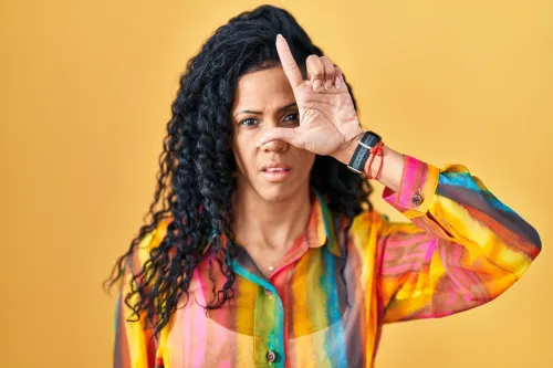 woman making a "loser" gesture with her hands
