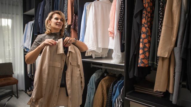 fashionable woman picking items out of closet