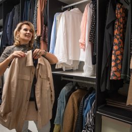 fashionable woman picking items out of closet