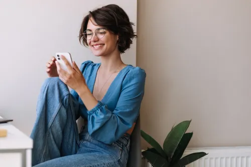 woman with glasses sending innocent flirty texts to her crush
