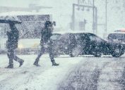 Pedestrians crossing a street during a snow storm