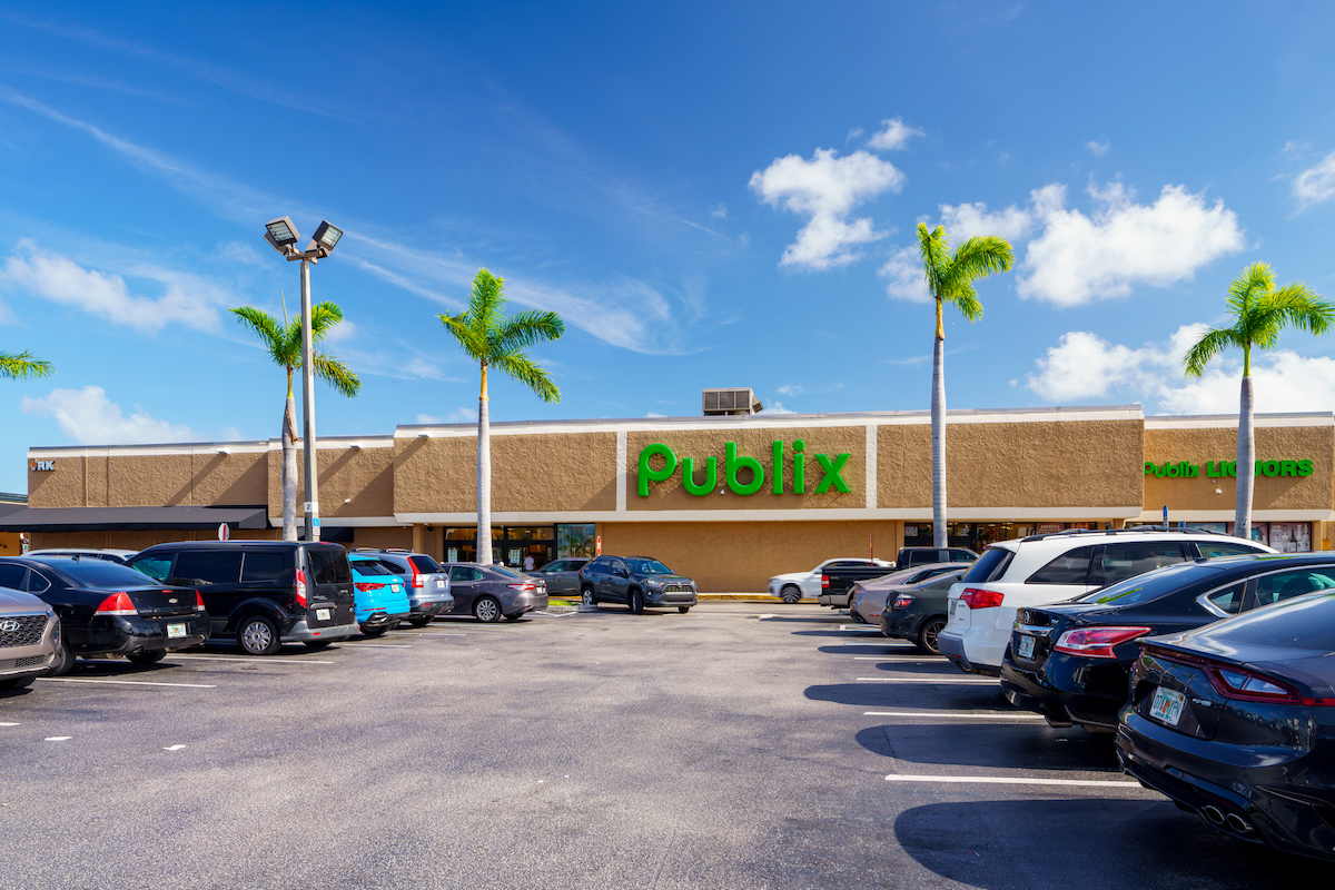A Publix grocery store and parking lot with palm trees on a sunny day