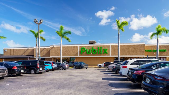 A Publix grocery store and parking lot with palm trees on a sunny day