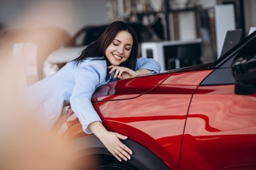 woman hugging her new car and deciding on a cool car name