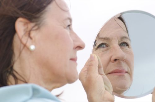 Portrait of a middle aged woman looking into a mirror