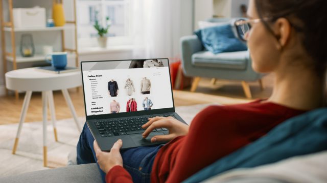 Young woman online shopping for clothes at home