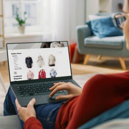 Young woman online shopping for clothes at home
