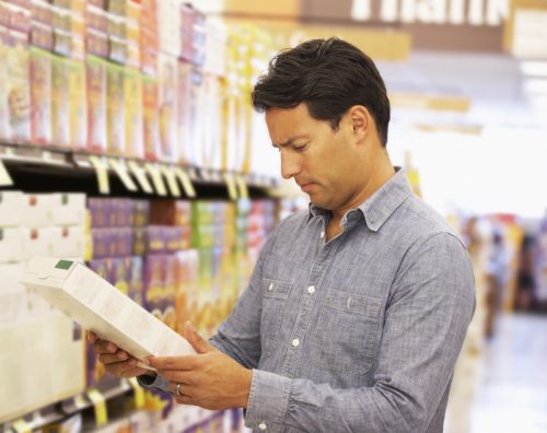man shopping and looking at cereal ingredients