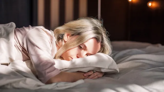 woman sad and sick in bed