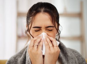 sick woman blowing nose