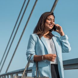 Beautiful business woman uses and talks on the phone abroad.