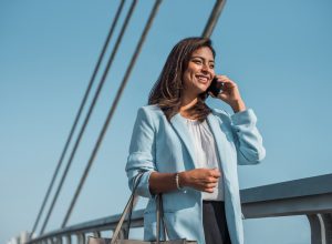 Beautiful business woman uses and talks on the phone abroad.