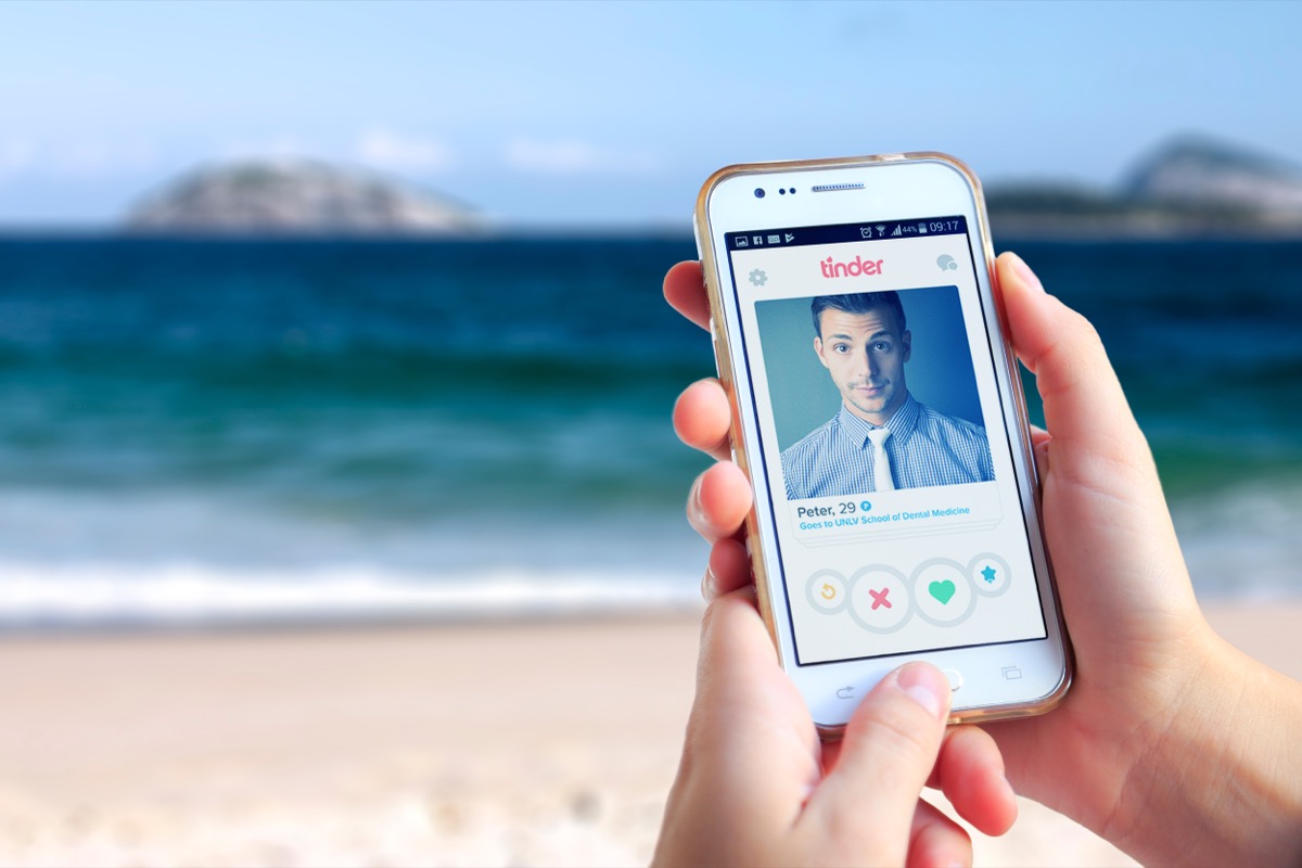 woman swiping through tinder at the beach