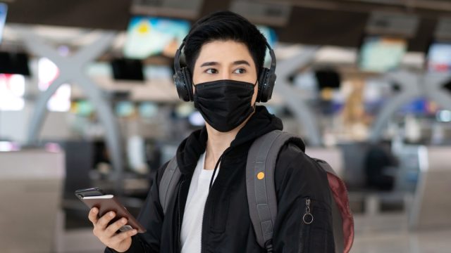 traveler wearing headphones at the airport