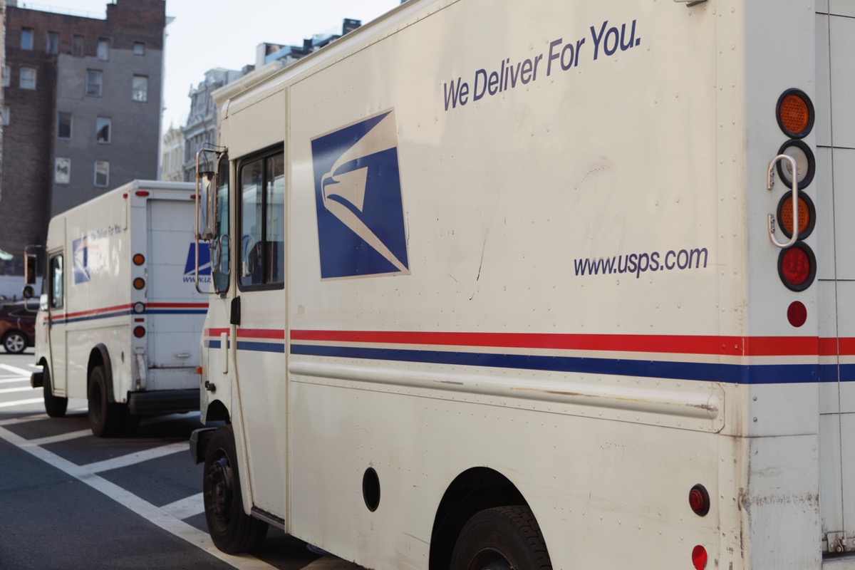 New York, NY, USA - April 26, 2013: Three US Postal Service delivery vans are parked beside the Canal Street Station on Church Street in Downtown Manhattan. The USPS uses these Grumman vans to collect and deliver bags of mail and packages to local drop off areas and to sorting offices. The eagles head logo printed on the rear of these trucks is a current advertising trademark used by the USPS. The USPS web site URL is printed on the side of the van. Red, white, and blue are the colors used by the USPS in their advertising.