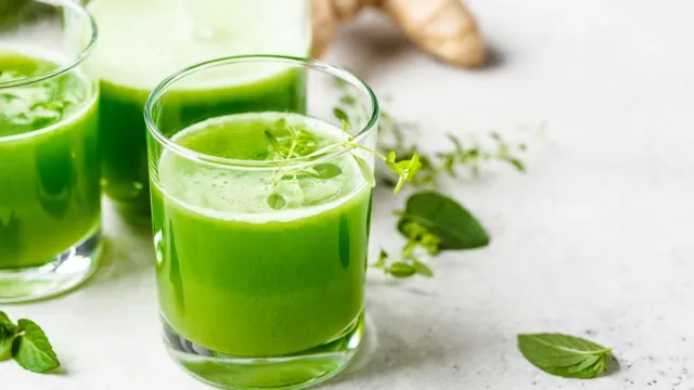 Green detox juice with ginger and mint in glasses and jars. Vegan detox concept.