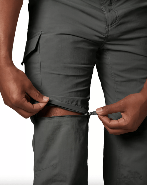 Close up of a man zippering off the bottom half of his convertible pants