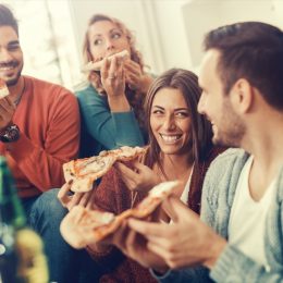 Friends Eating Pizza Together in living room