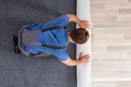 Top-down view of a Man Installing Carpet