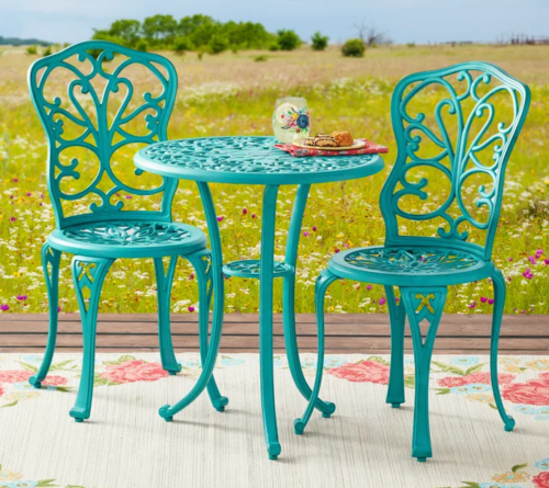 teal bistro set on an outdoor rug in a field