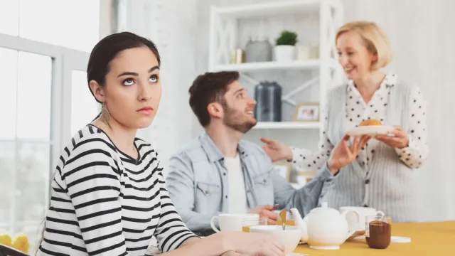 Woman Rolling Eyes at People arguing next to her at the kitchen table