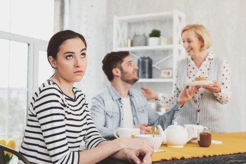 Woman Rolling Eyes at People arguing next to her at the kitchen table