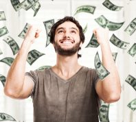 Portrait of a young man throwing money into the air against a white background