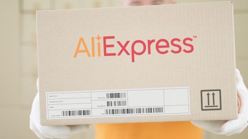 Warehouse worker holds box with printed ALIEXPRESS logo on it.