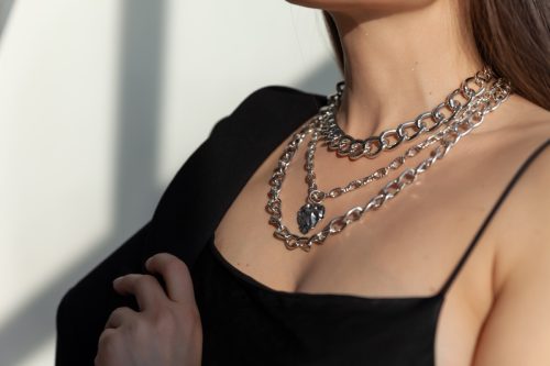 Beautiful model brunette in modern silver metal necklace, many chains