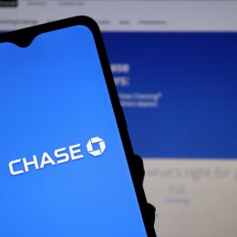 Close up of a phone with the Chase bank logo against a computer screen