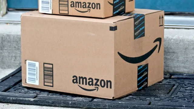 Close up of a big and a small Amazon box piled outside a door
