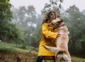 Young woman enjoying rainy day with her dog