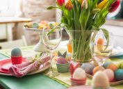 Colorful decorated Easter Place Setting with Easter Eggs, flowers on the table