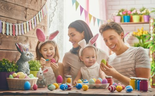 Mother, father and daughters painting Easter eggs