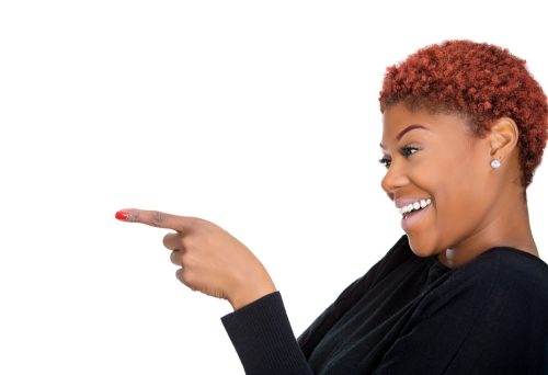 woman smiling and pointing her finger against a white background