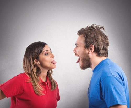 man and woman sticking their tongues out at each other