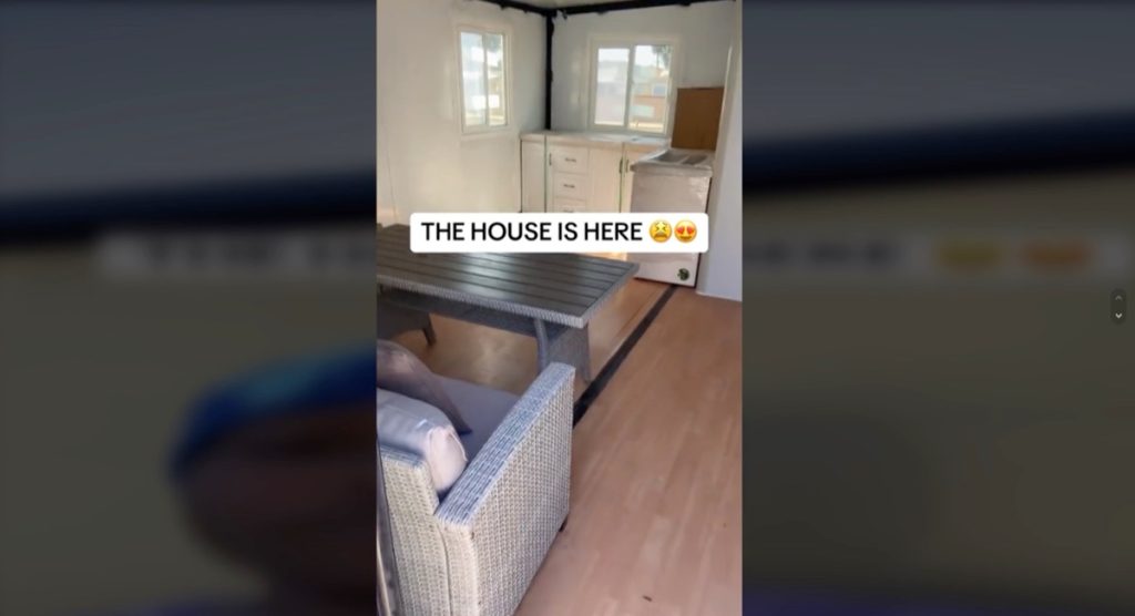 The interior of a tiny home purchased off of Amazon with a couch and kitchenette