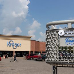 Close up of a Kroger shopping cart with a store in the background