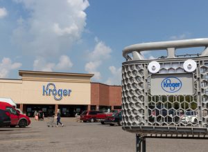 Close up of a Kroger shopping cart with a store in the background