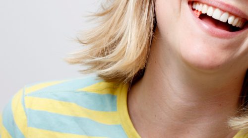 close-up of a woman chewing taffy and laughing