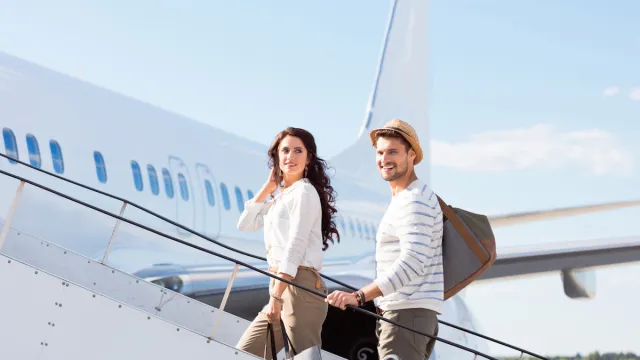 Beautiful young couple boarding a flight. Man and woman going on a holiday.