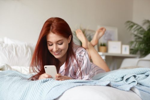 woman laying in bed texting her crush