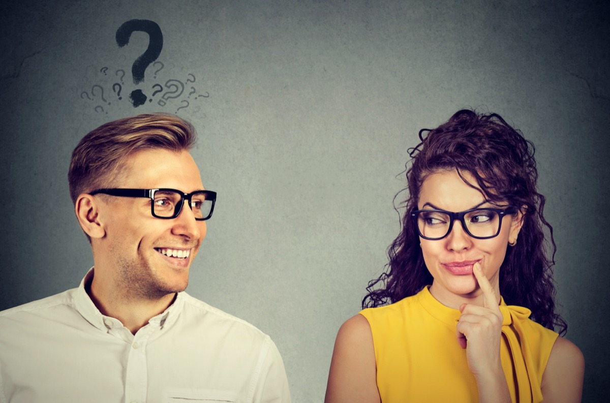 man looking at woman with question mark over his hed