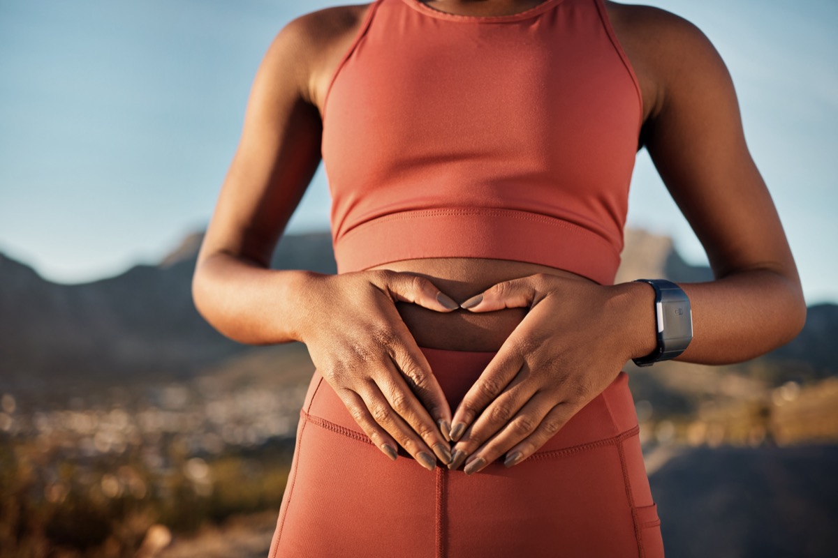 woman with hands over stomach representing digestive health